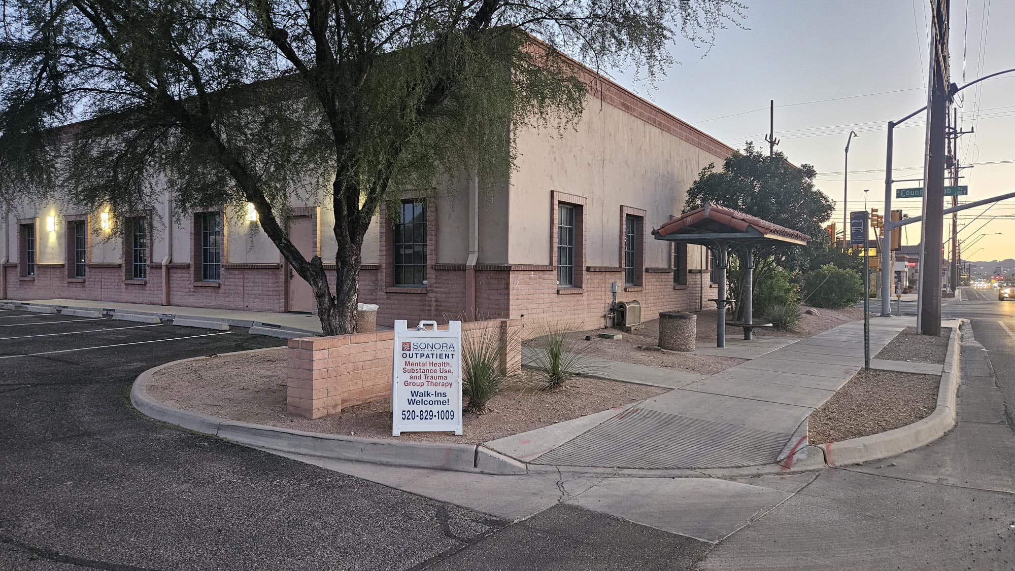 Street view of building with sign for walk-in services