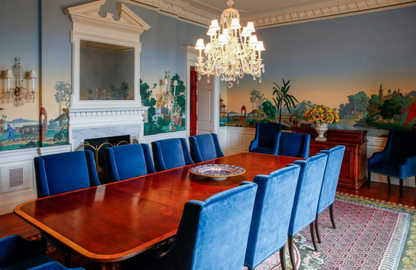 Meeting room with long wood table, blue chairs, and chandelier