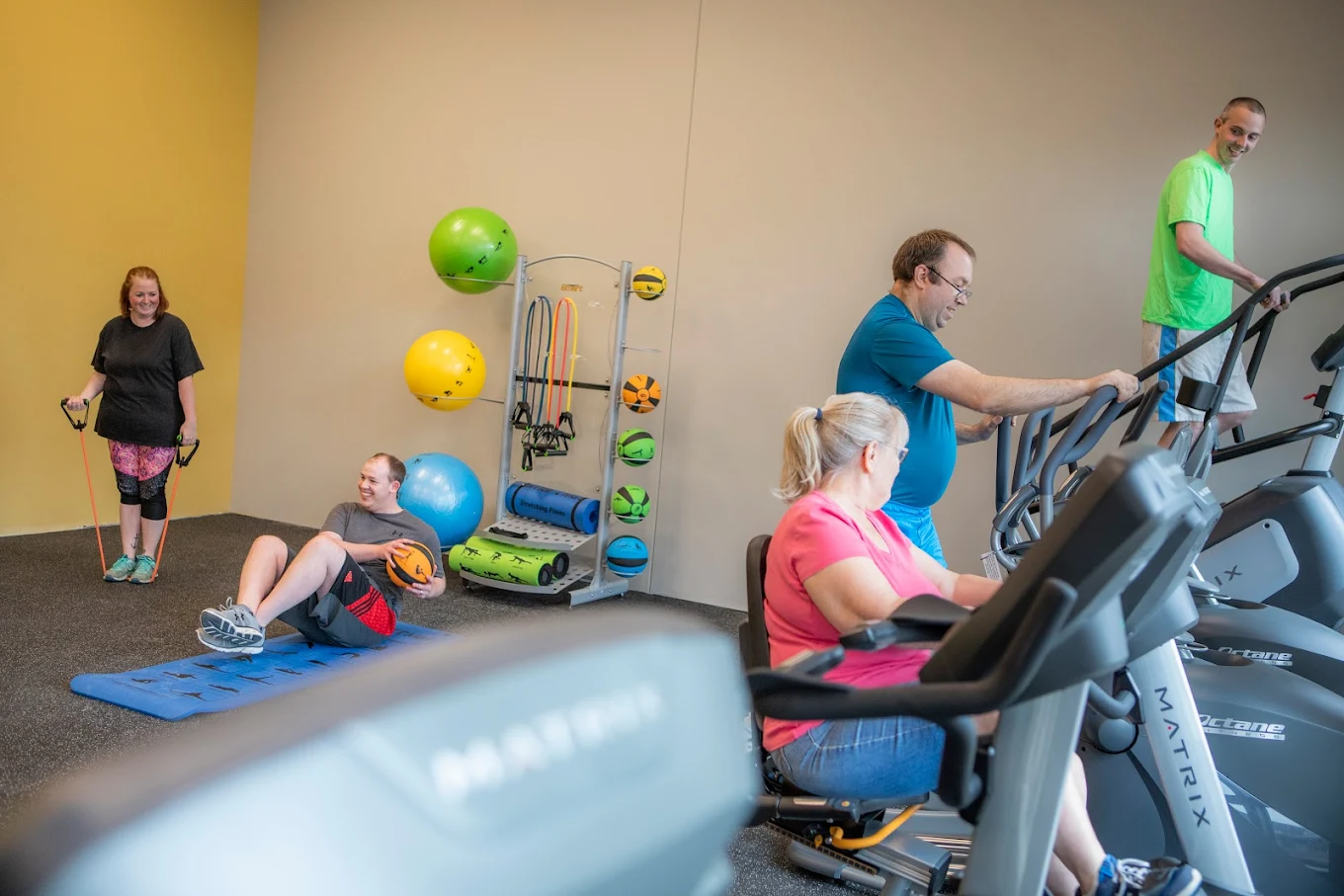 Residents using exercise equipment in on-site fitness room