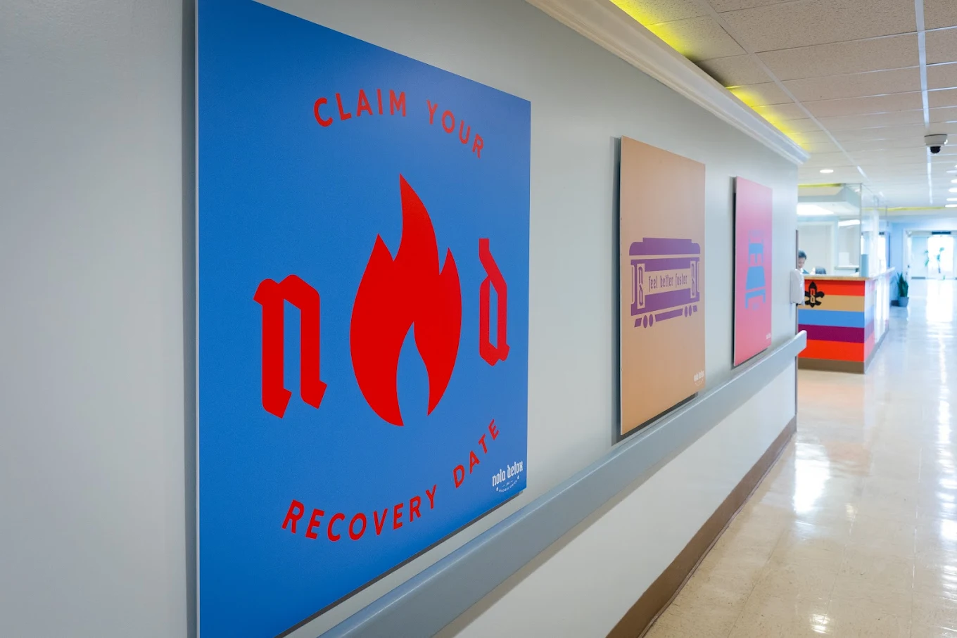 Bright hallway at NOLA Detox with colorful motivational posters including “Claim Your Recovery Date” and other themed graphics