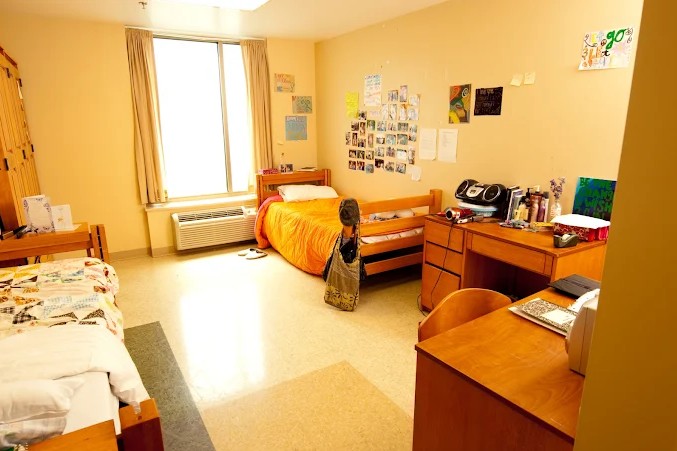 Shared patient room with two beds, desks, and window