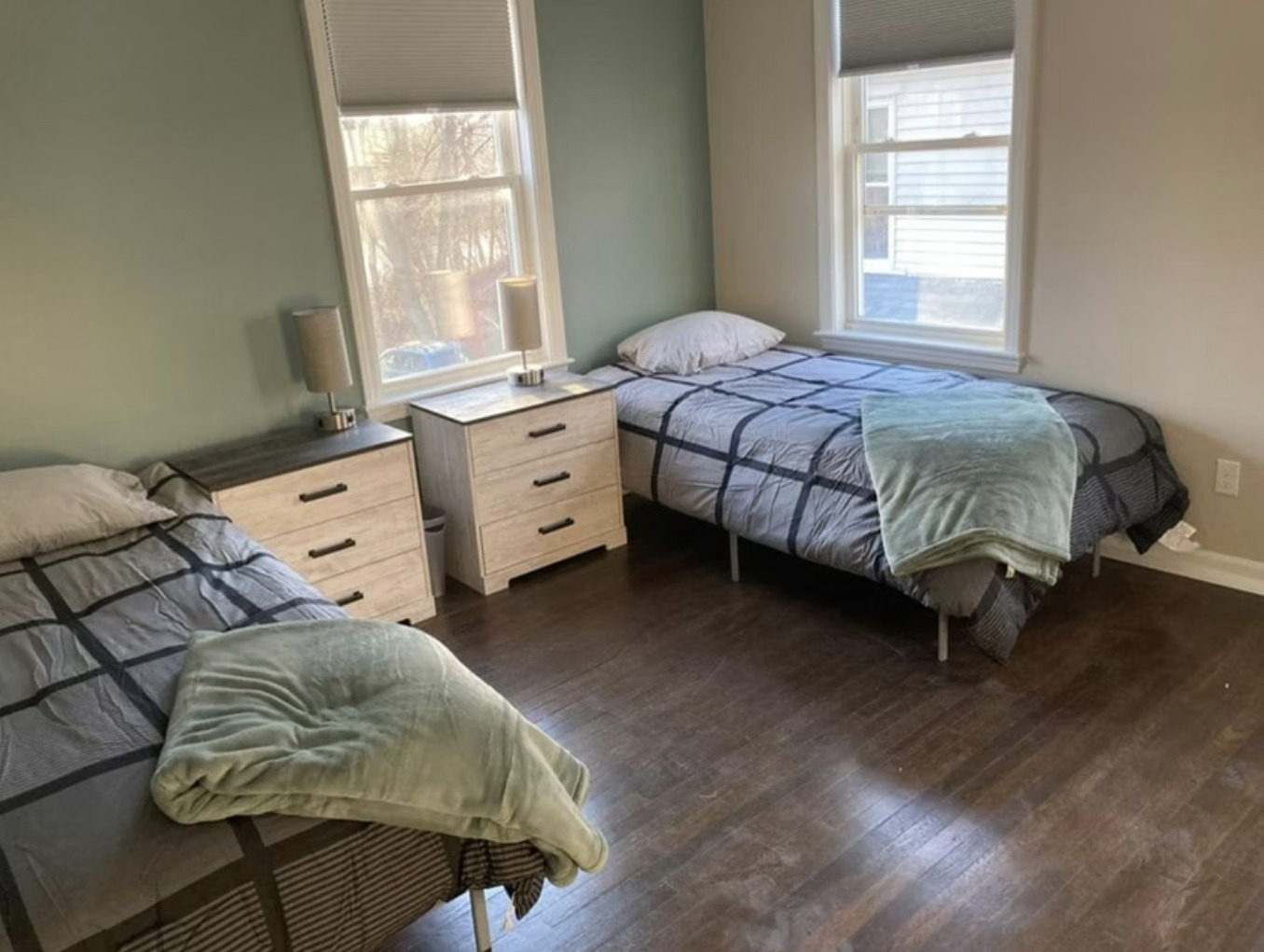 Two twin beds with gray bedding and nightstands