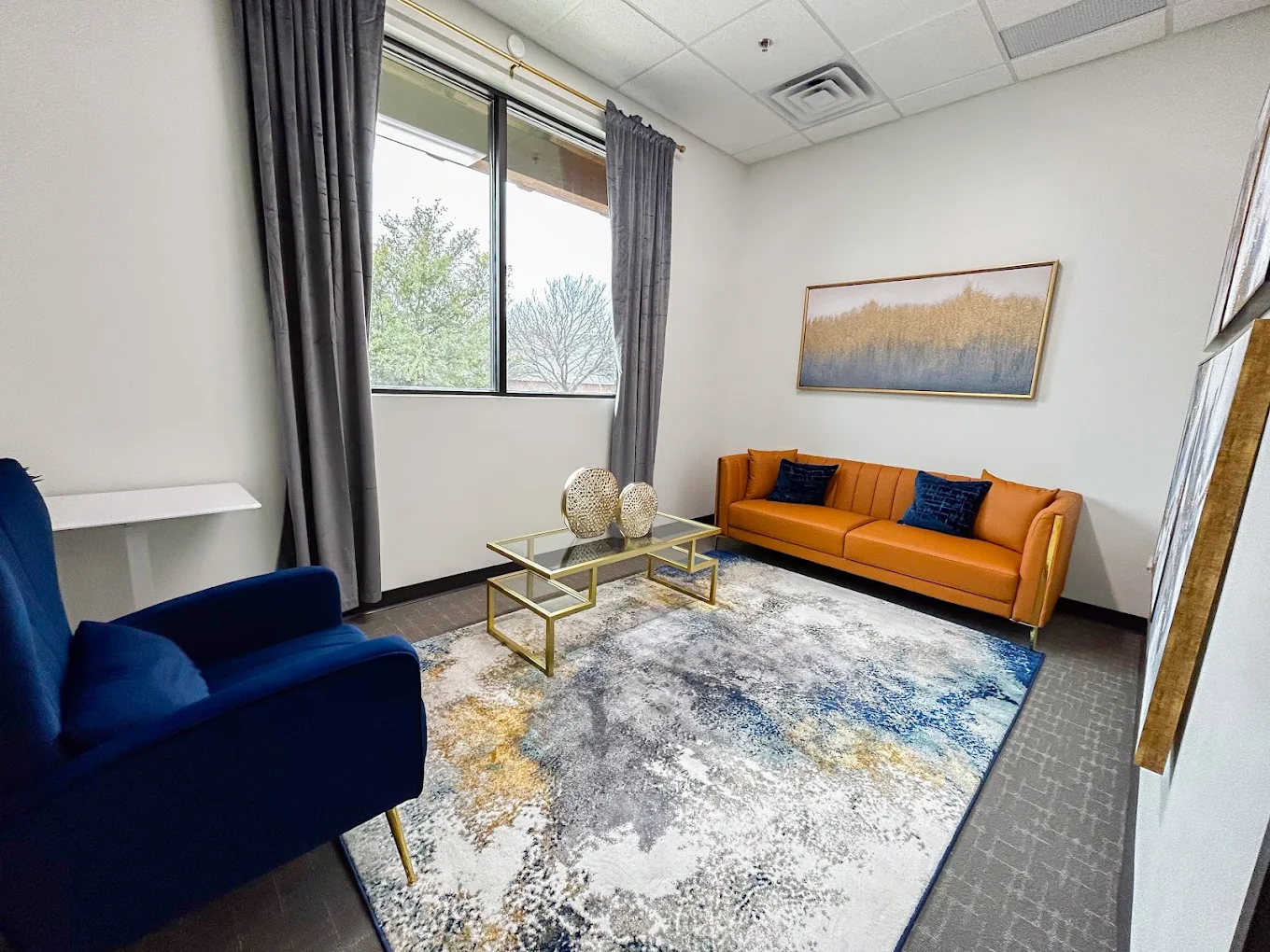 Private office with orange sofa and blue chair