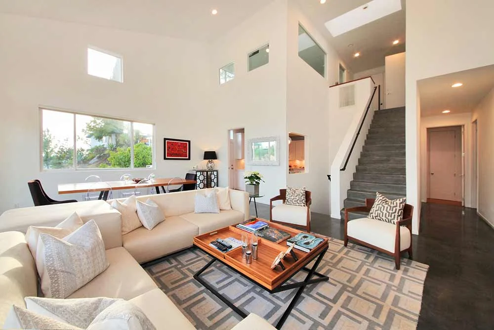 Bright living room with white sectional couch, high ceilings, and modern decor in Los Angeles treatment center