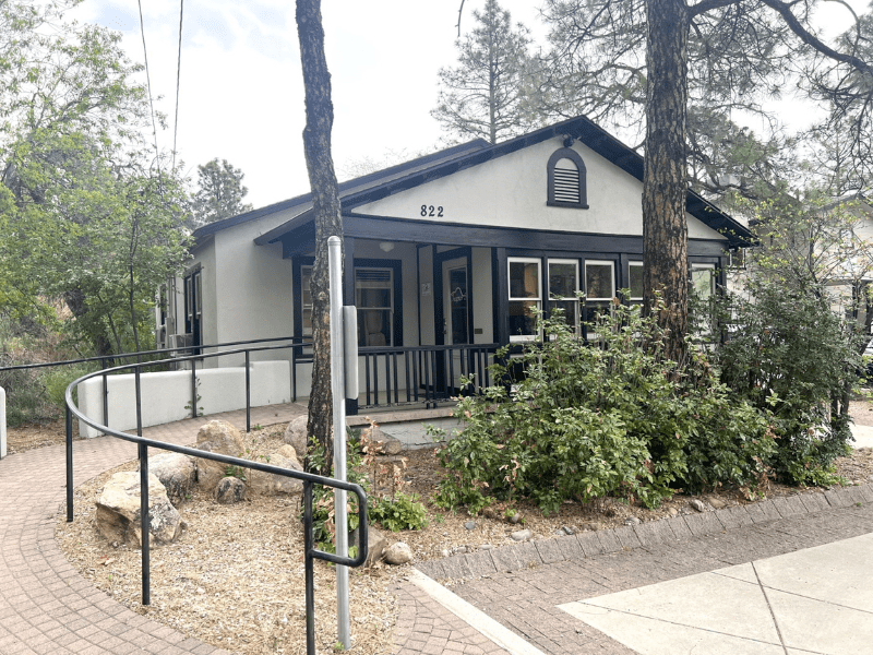 Single-story house with ramp and trees in front yard