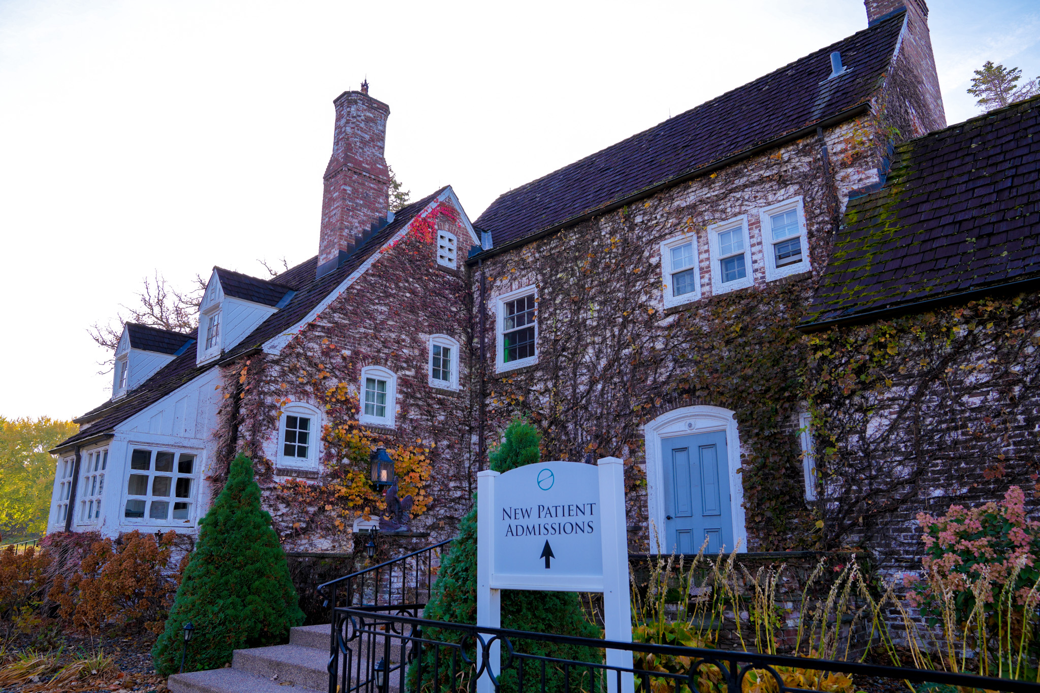 Building entrance with sign directing new patient admissions.