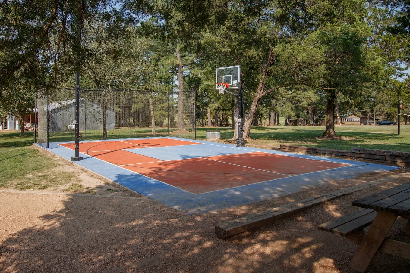 Outdoor basketball court surrounded by trees on the campus