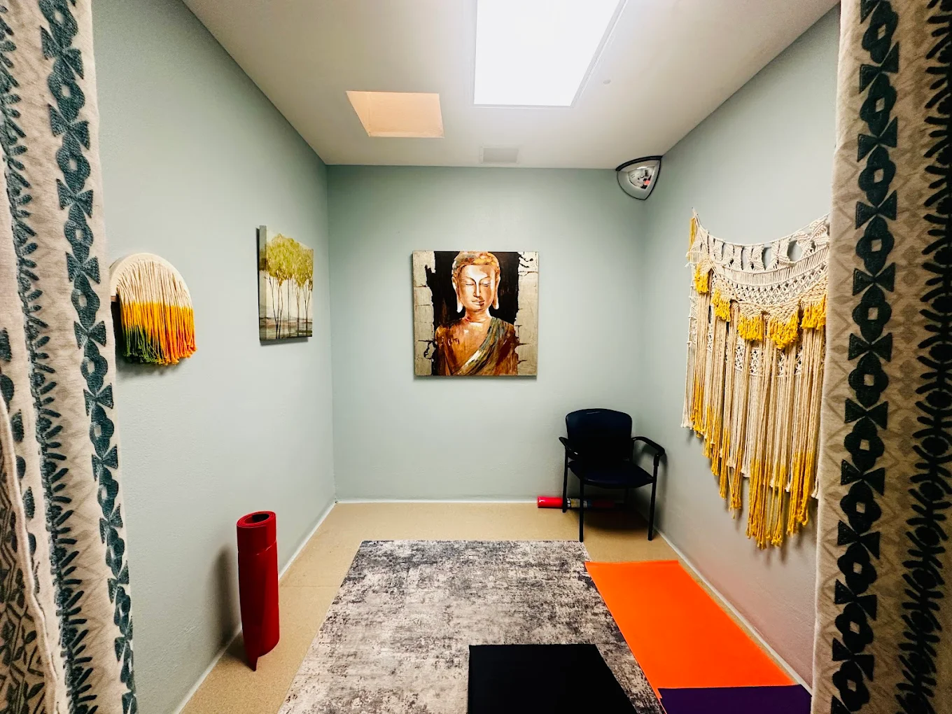 Serene therapy space with yoga mats, artwork, and a peaceful atmosphere
