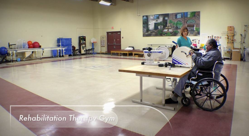 Gym with therapy equipment and patient in wheelchair