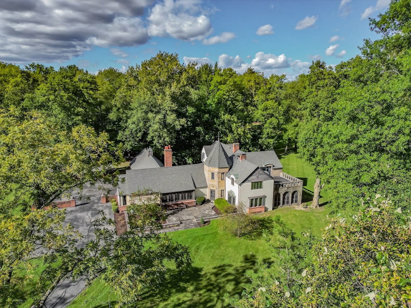 Aerial view of a Tudor-style rehab center surrounded by trees.
