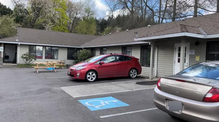 Single-story rehab facility with parking and picnic table