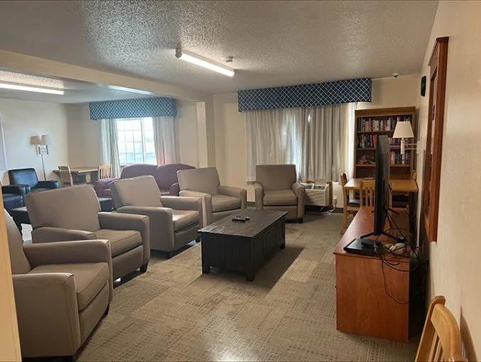 Common area with armchairs, TV, and bookshelf