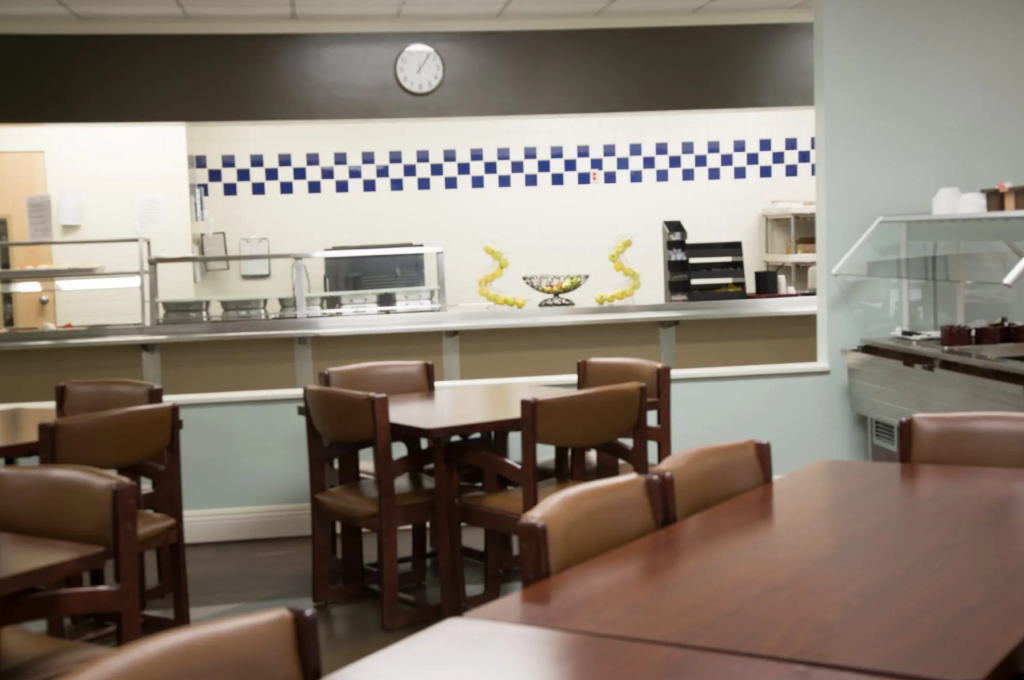 Dining tables and serving area in facility cafeteria