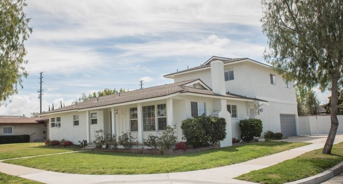wo-story white rehab facility with lawn and sidewalk view