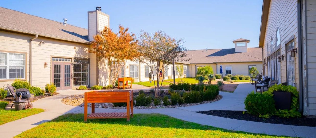 Landscaped outdoor courtyard with walking paths, benches, and green space for relaxation
