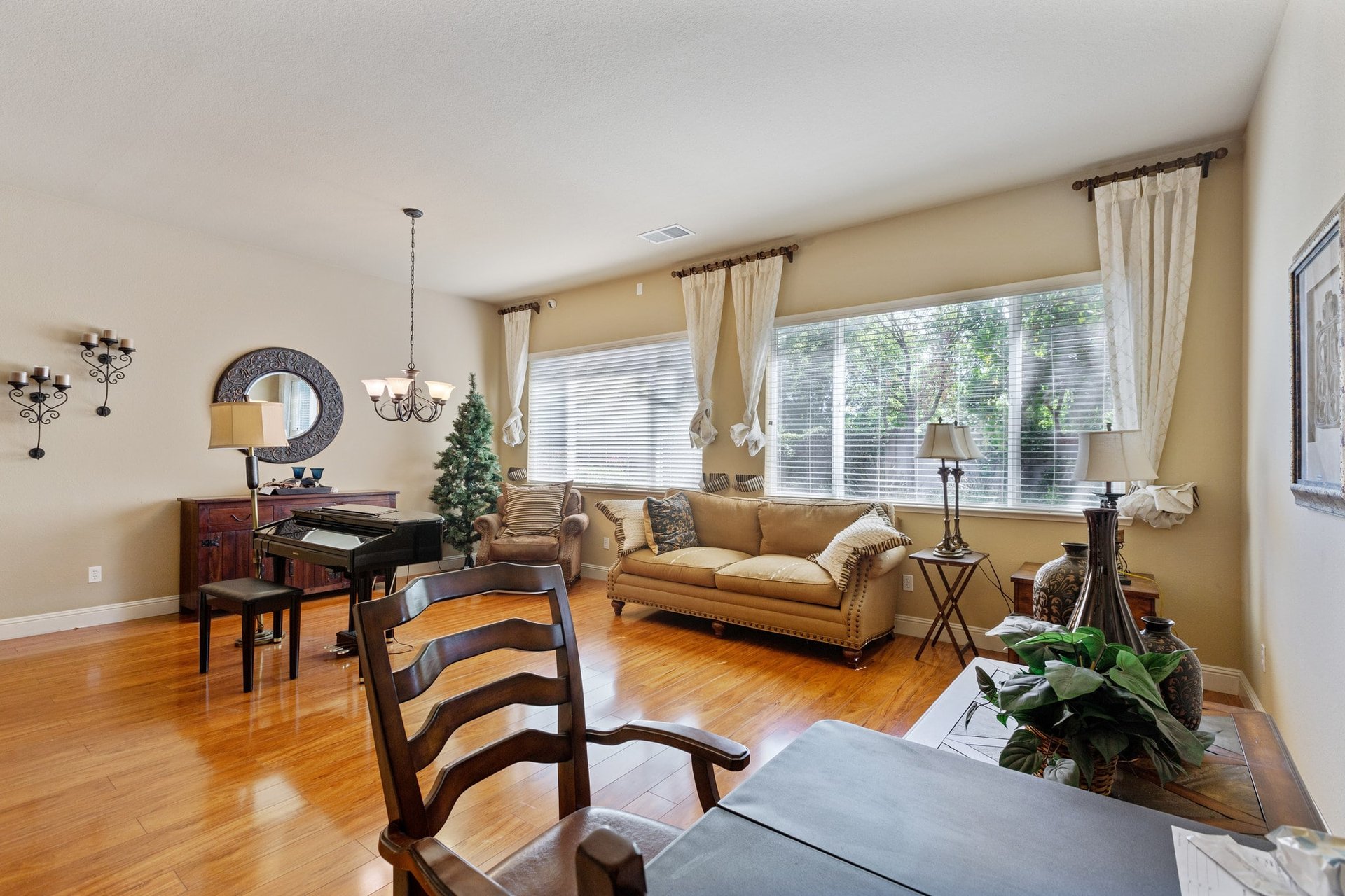 Living room with piano, sofa, and large windows