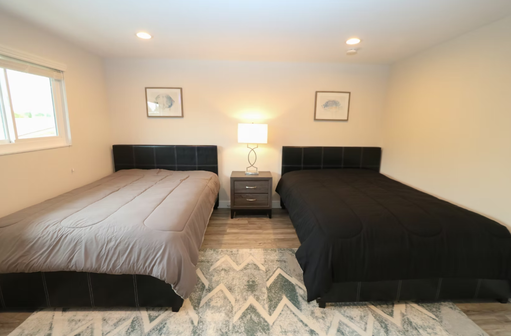 Bedroom with two queen beds and nightstand lamp