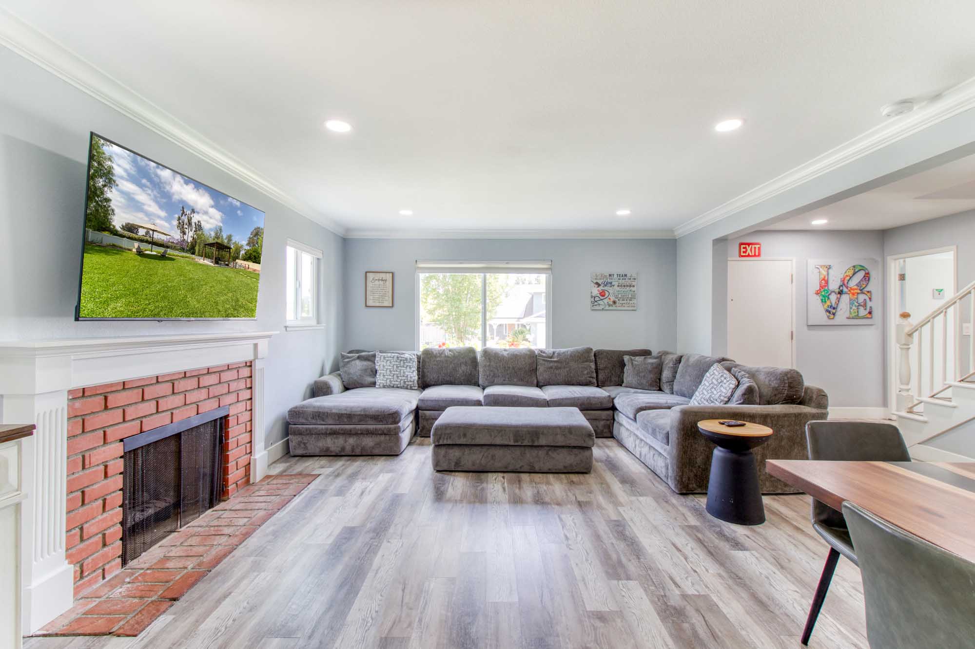 Cozy lounge with gray sectional sofa and brick fireplace