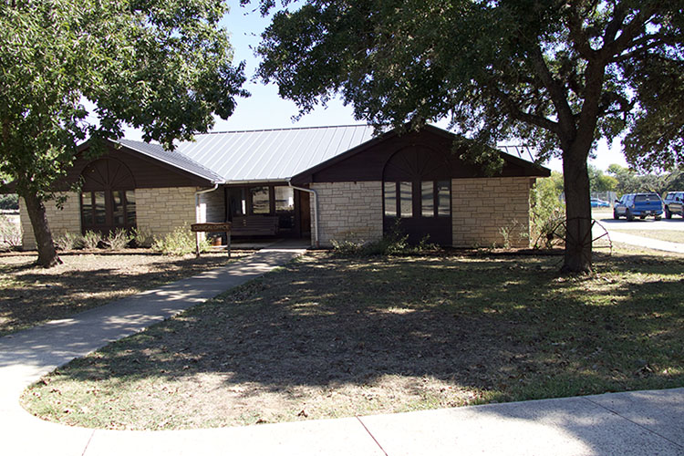 Exterior of a cabin under trees at Warriors Heart facility