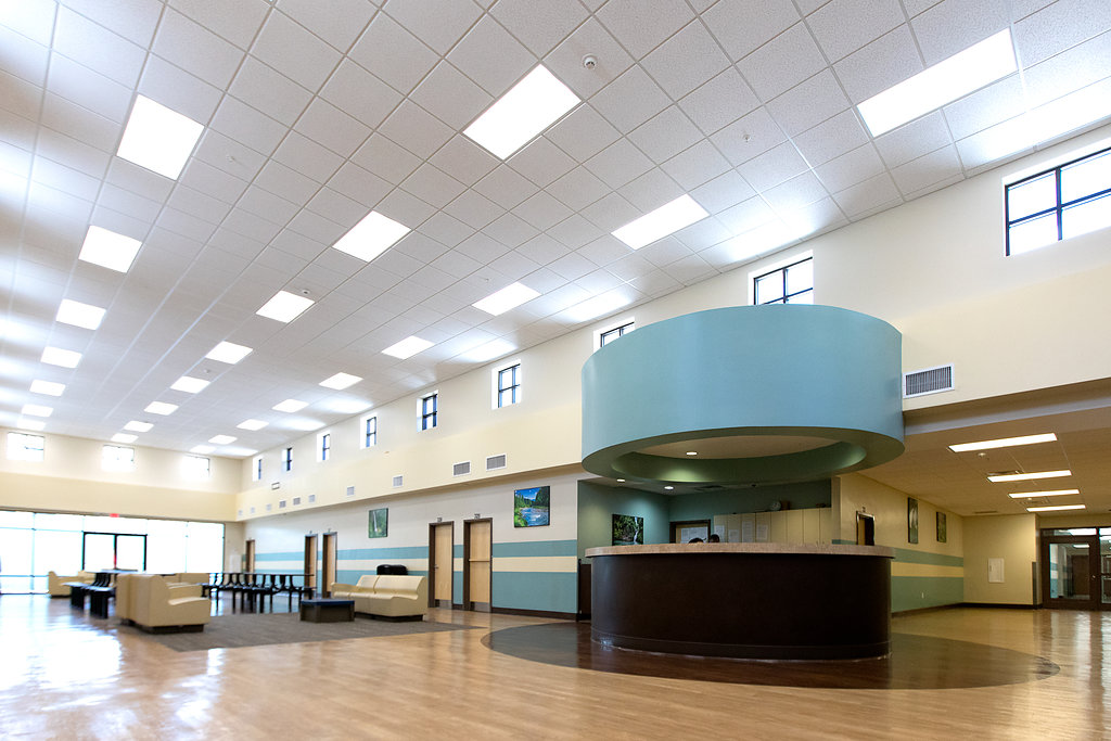 Reception desk under a round teal structure in open room