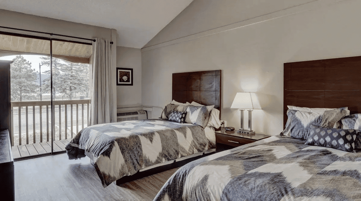 Shared bedroom with two beds and a balcony.