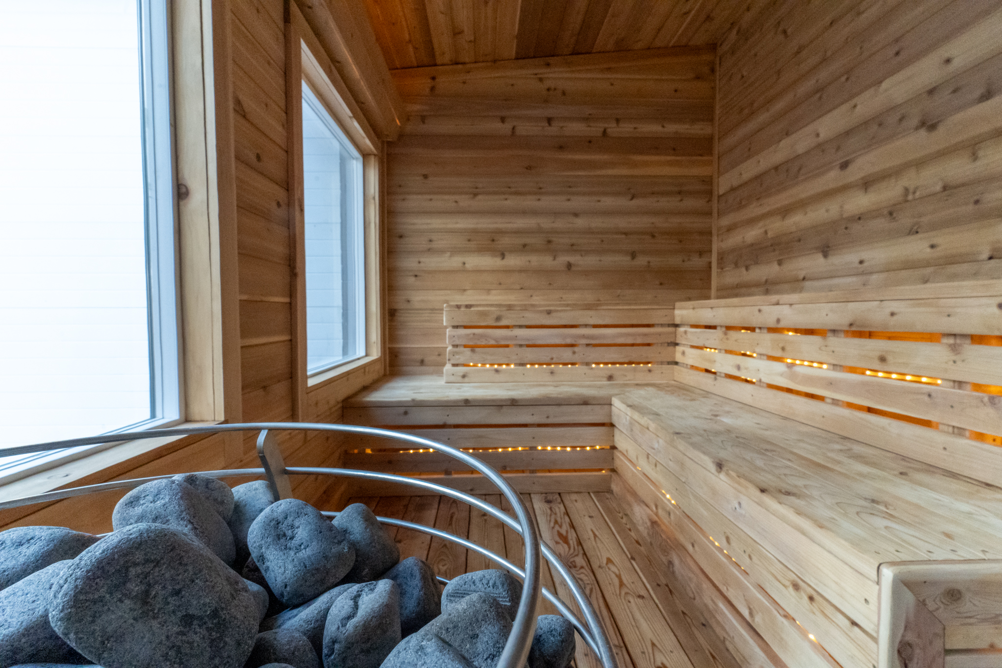 Wood-lined sauna with benches and heated stones