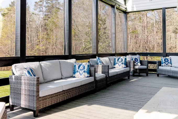 Sunroom with cushioned wicker sofas and pillows