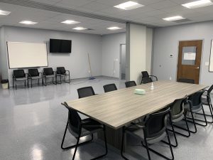 Large table with chairs and wall-mounted screens
