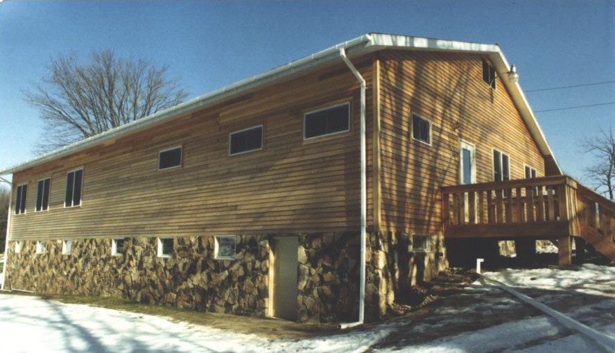 Wood-sided residential building with stone foundation