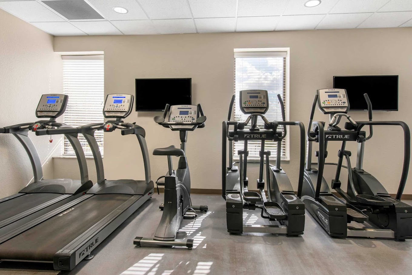 A well-equipped gym with treadmills, ellipticals, and exercise bikes.