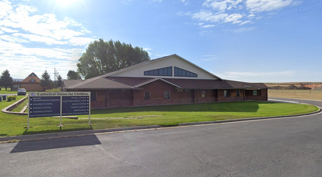 Brick and wood building of Cathedral Home for Children under blue sky
