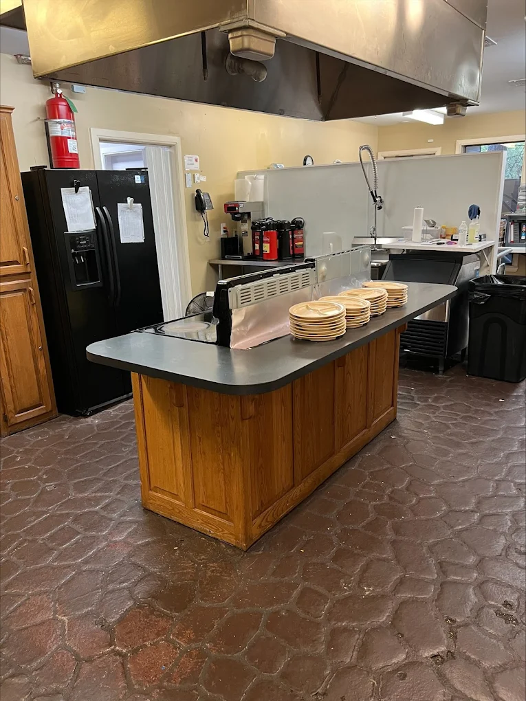 Kitchen with serving counter, fridge, and dining setup