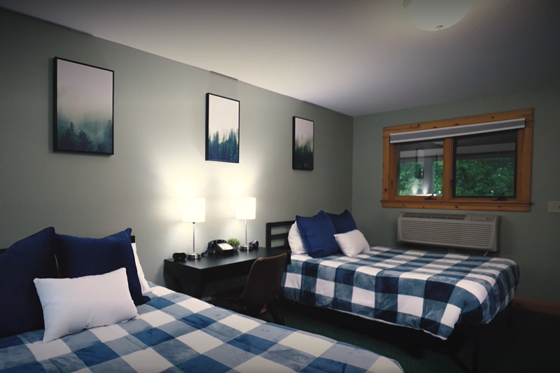 Shared bedroom with two beds and a desk.