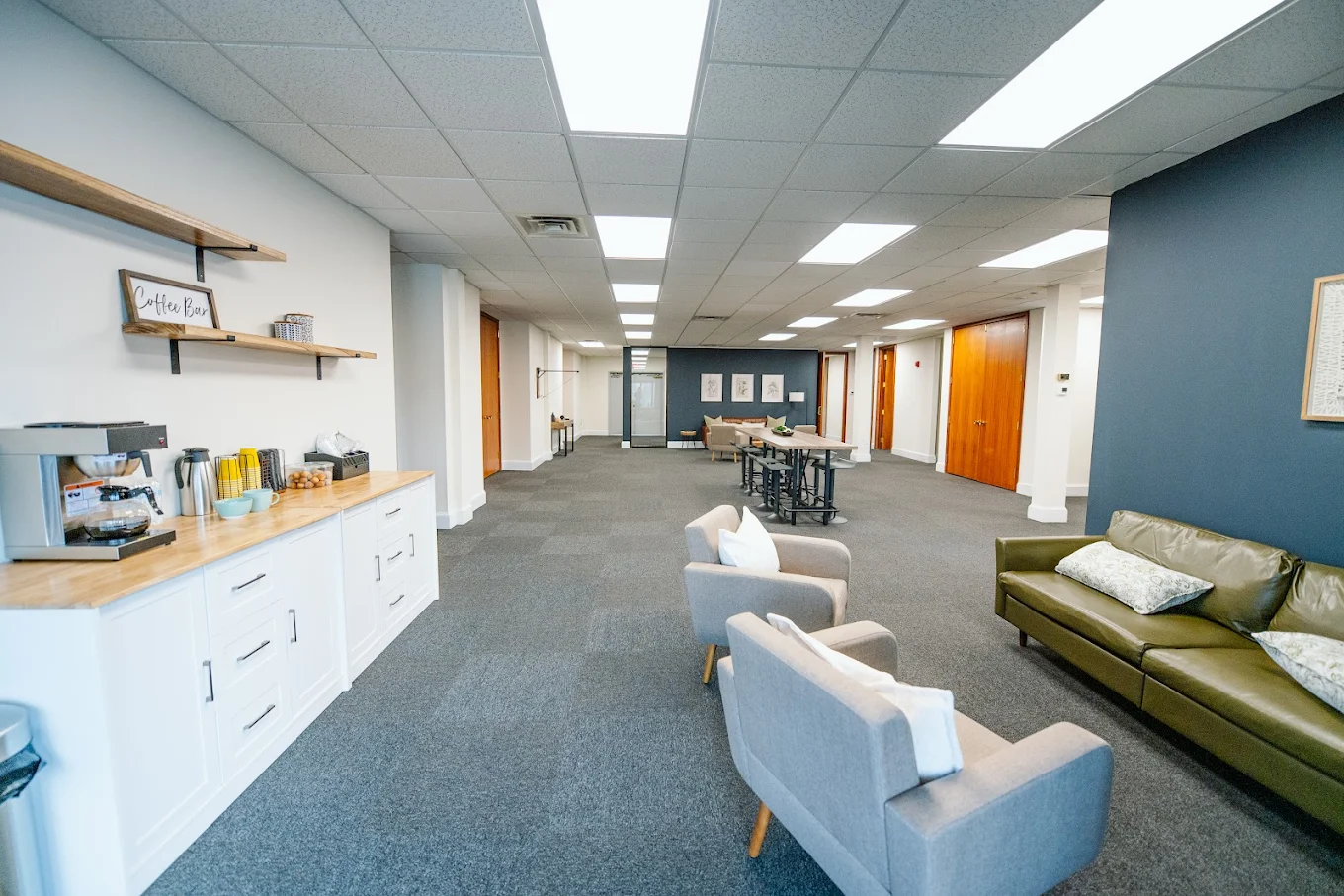 Lounge area with coffee station, seating, and tables