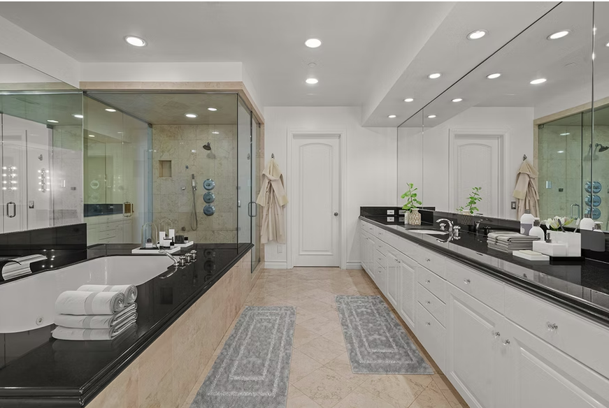 Spacious bathroom with soaking tub, glass shower, and double vanity