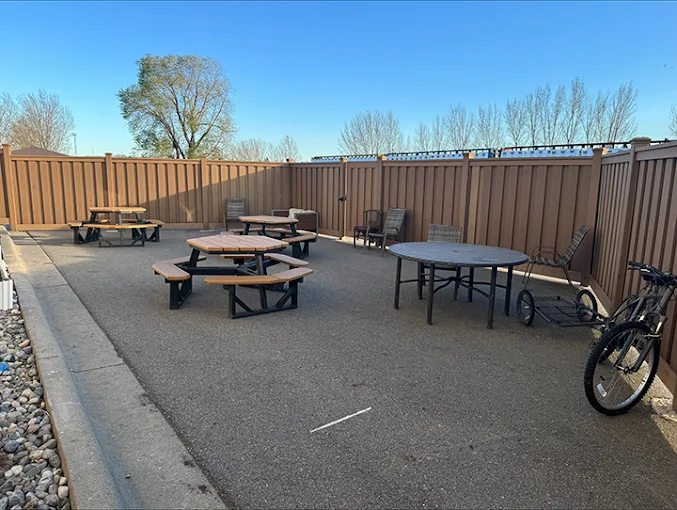 Fenced patio with picnic tables and seating