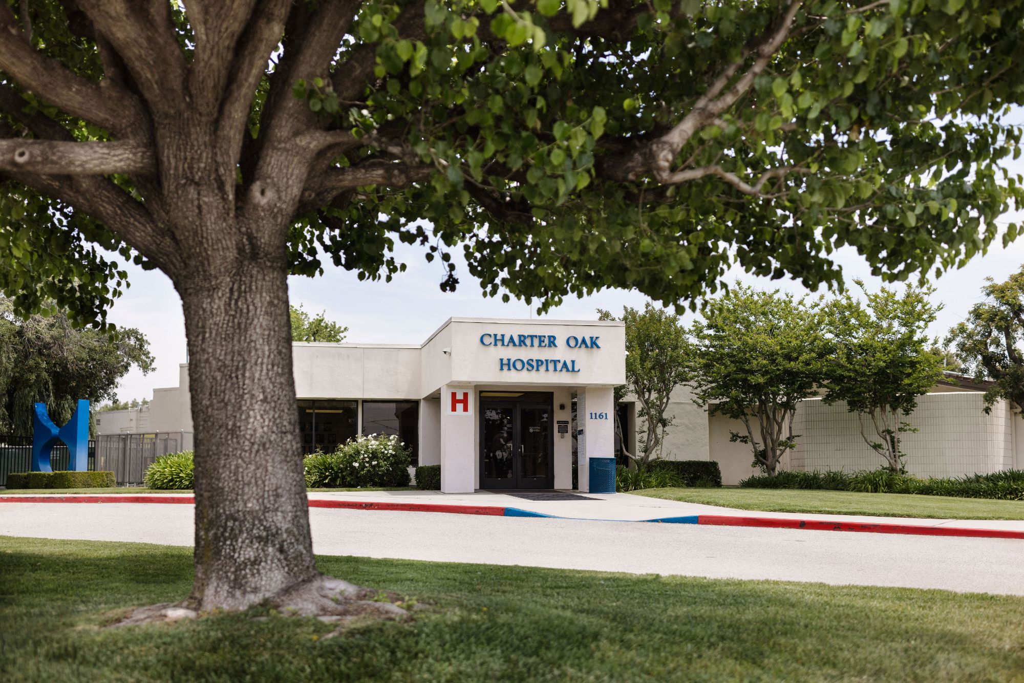 White medical building entrance with hospital sign