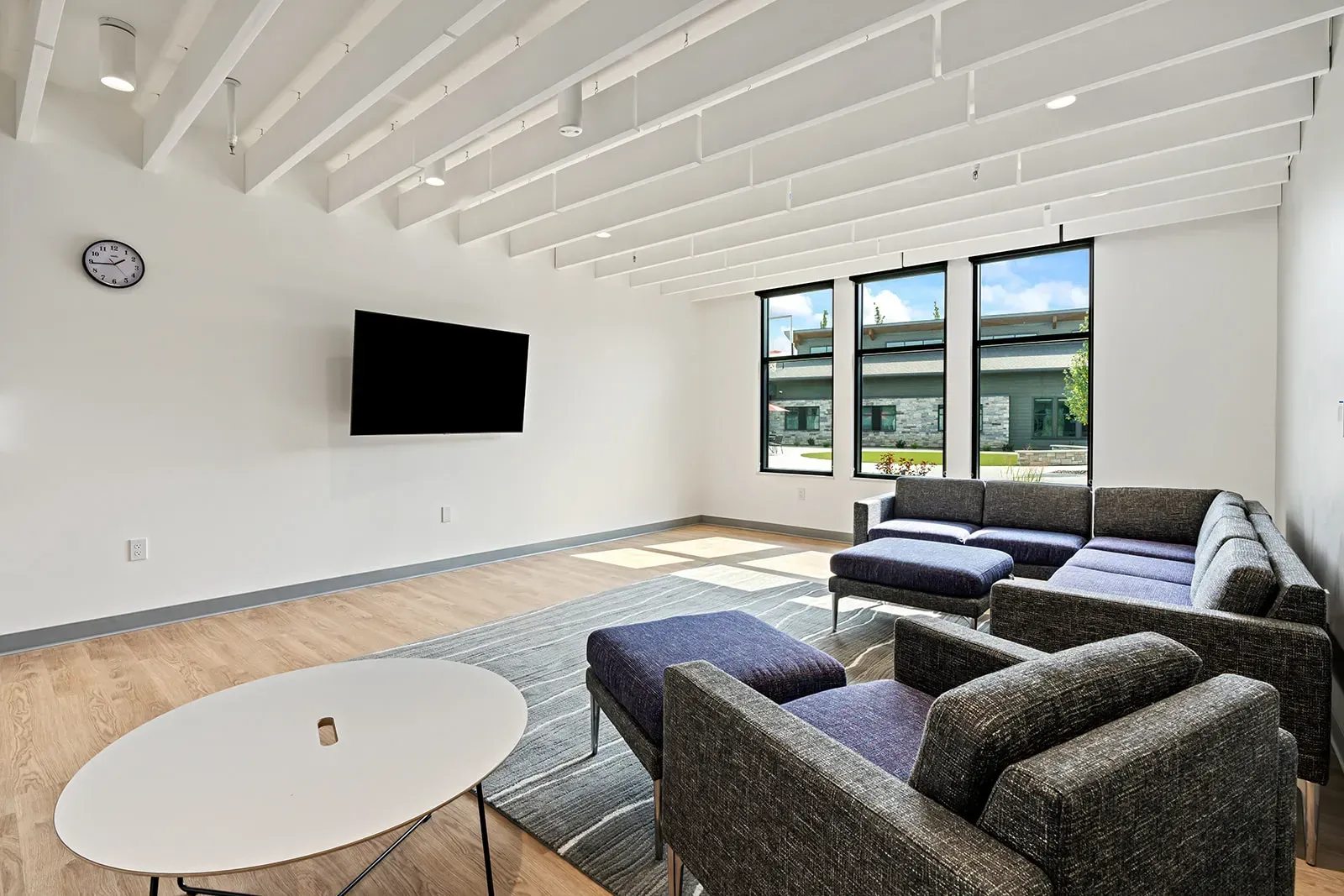 Bright lounge with sectional seating and wall-mounted TV