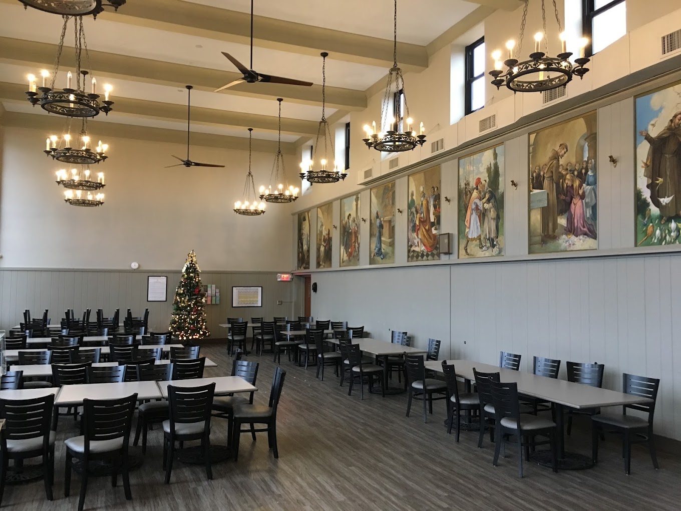 Dinning hall with long tables and chairs with wall decor. 