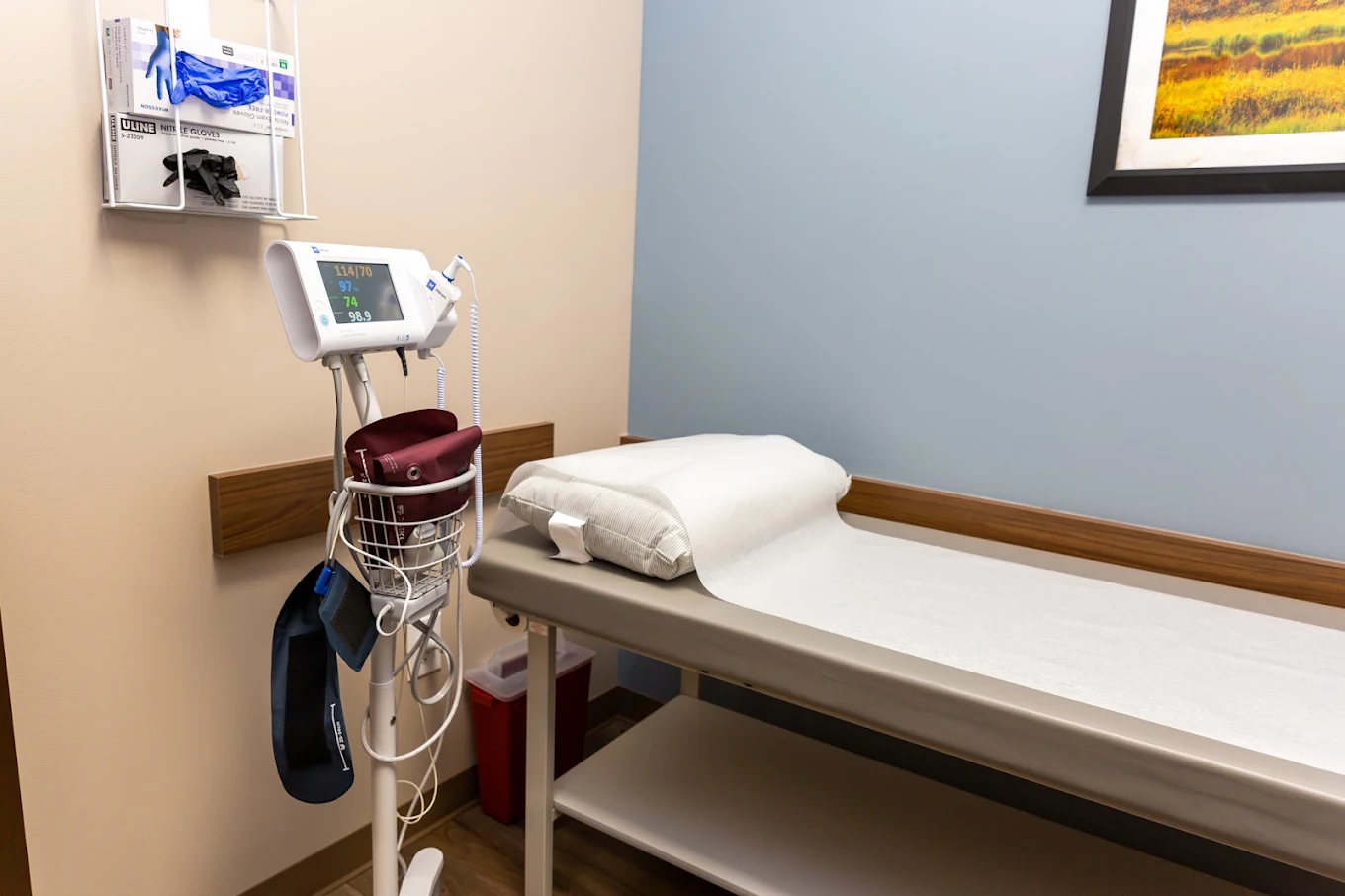 BrightView Danville clinical room with exam table, vital signs monitor, medical supplies, and blue accent wall