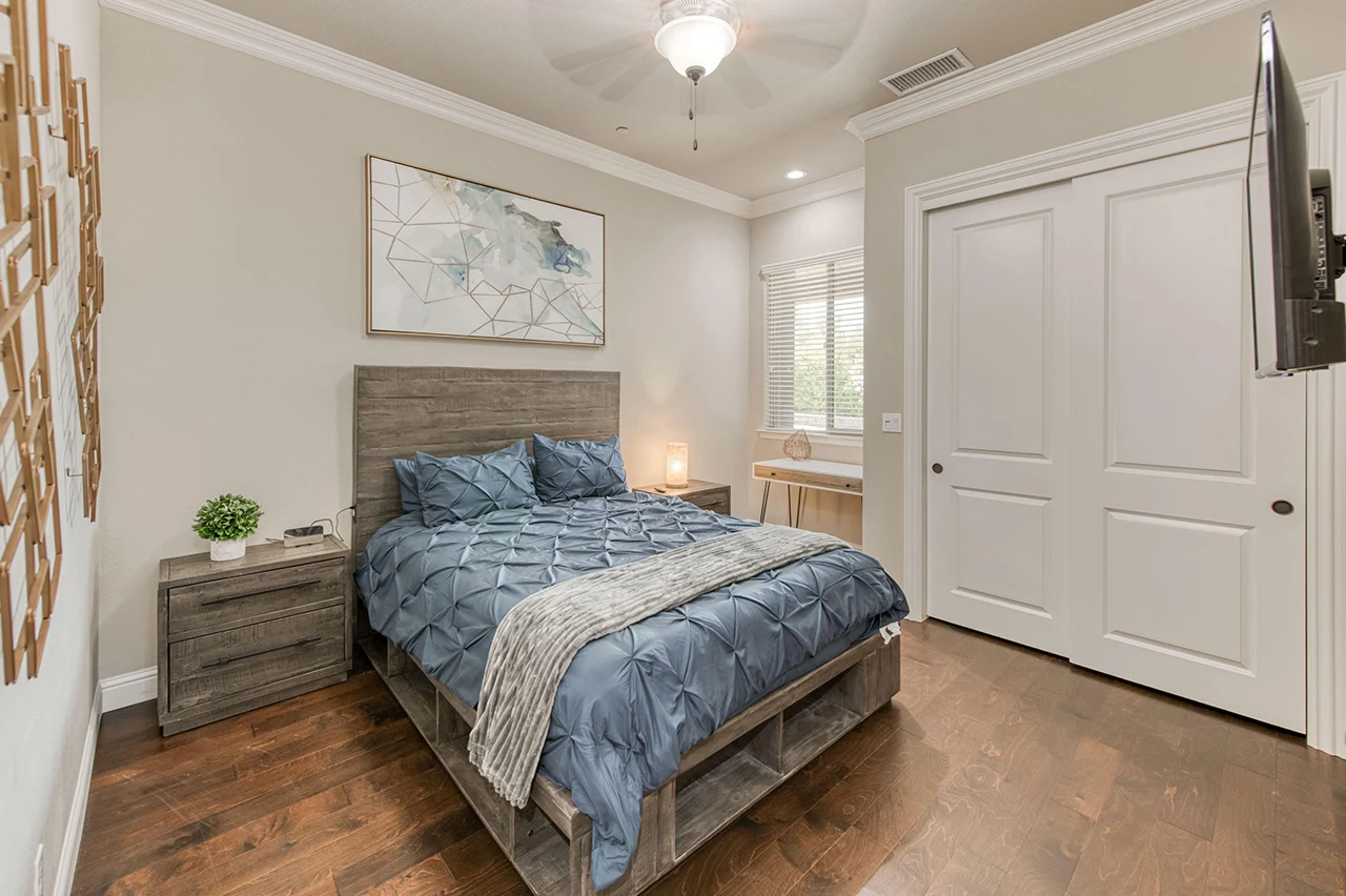 Bedroom with wood floors, queen bed, and large closet