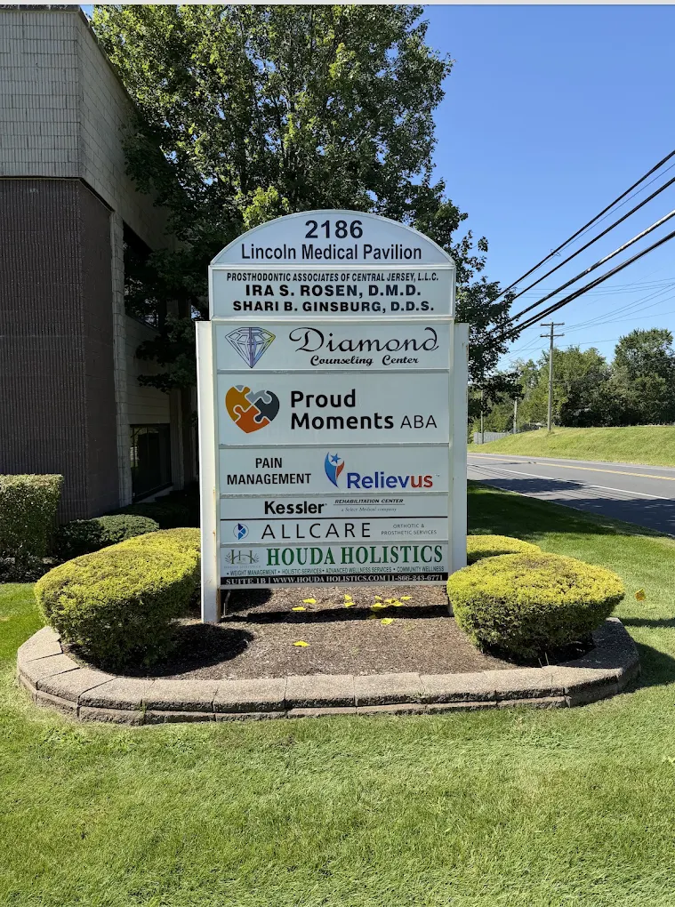 Office directory sign surrounded by shrubs and lawn