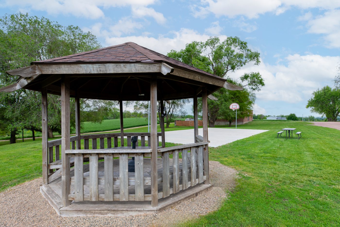 Wooden gazebo beside outdoor recreation and basketball area on treatment center campus