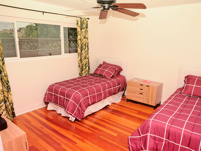 Bedroom with two twin beds and a ceiling fan.