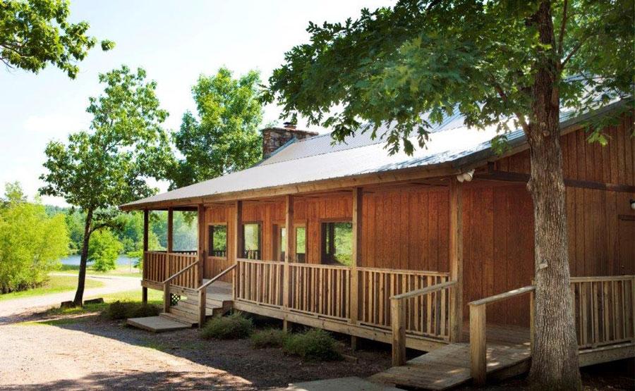 Wooden cabin with a covered porch surrounded by trees