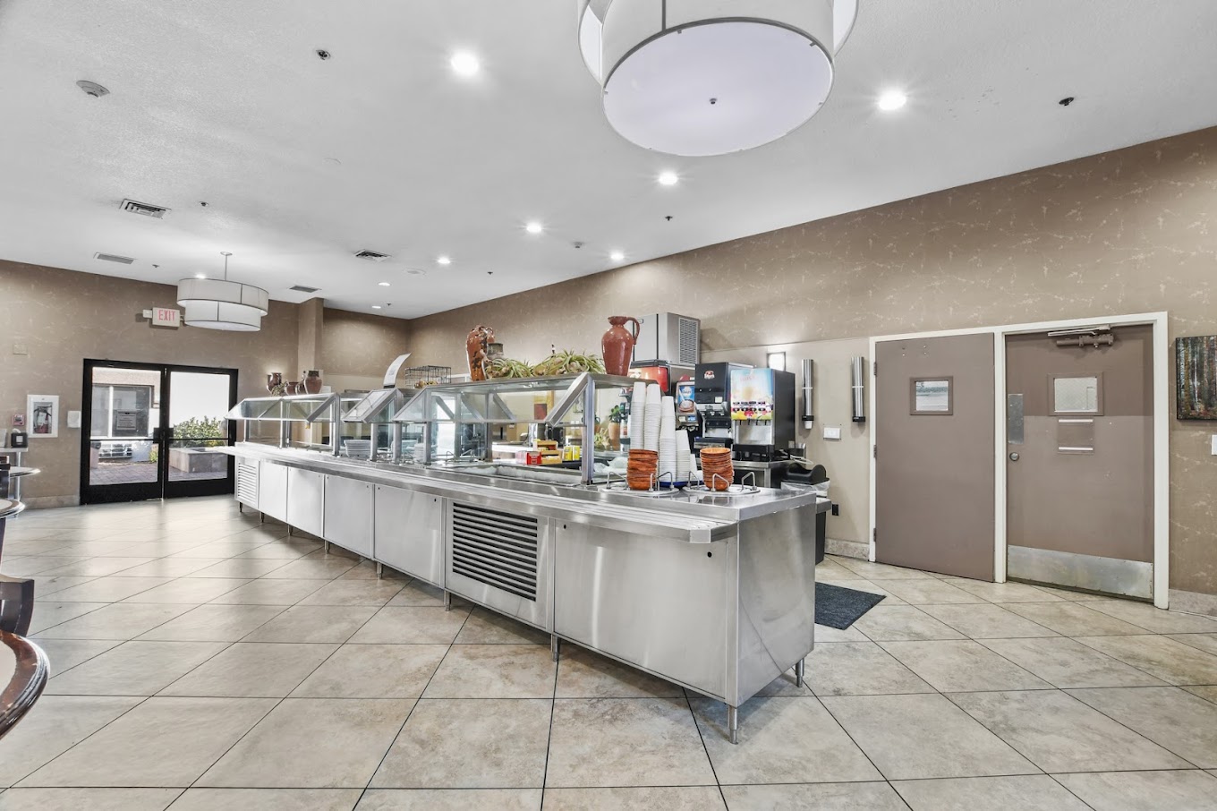 Modern cafeteria with stainless steel counters and food stations