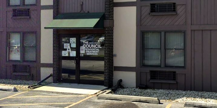 Building entrance with green awning and glass door