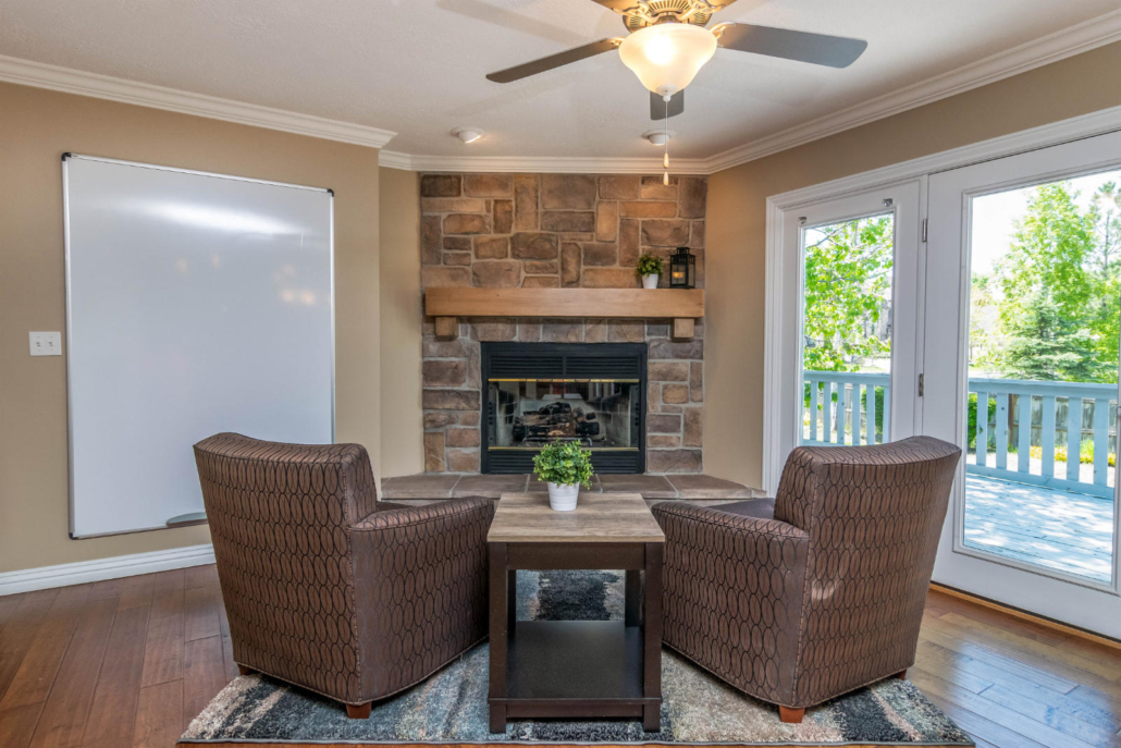 Fireplace room with two chairs and natural light