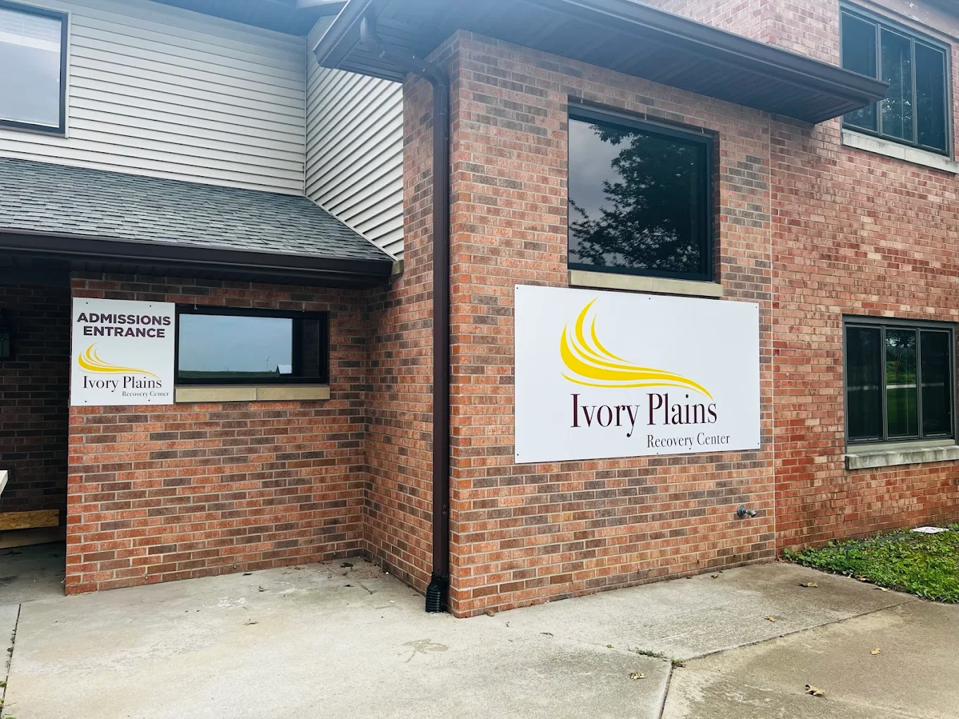Brick building entrance with Ivory Plains signage
