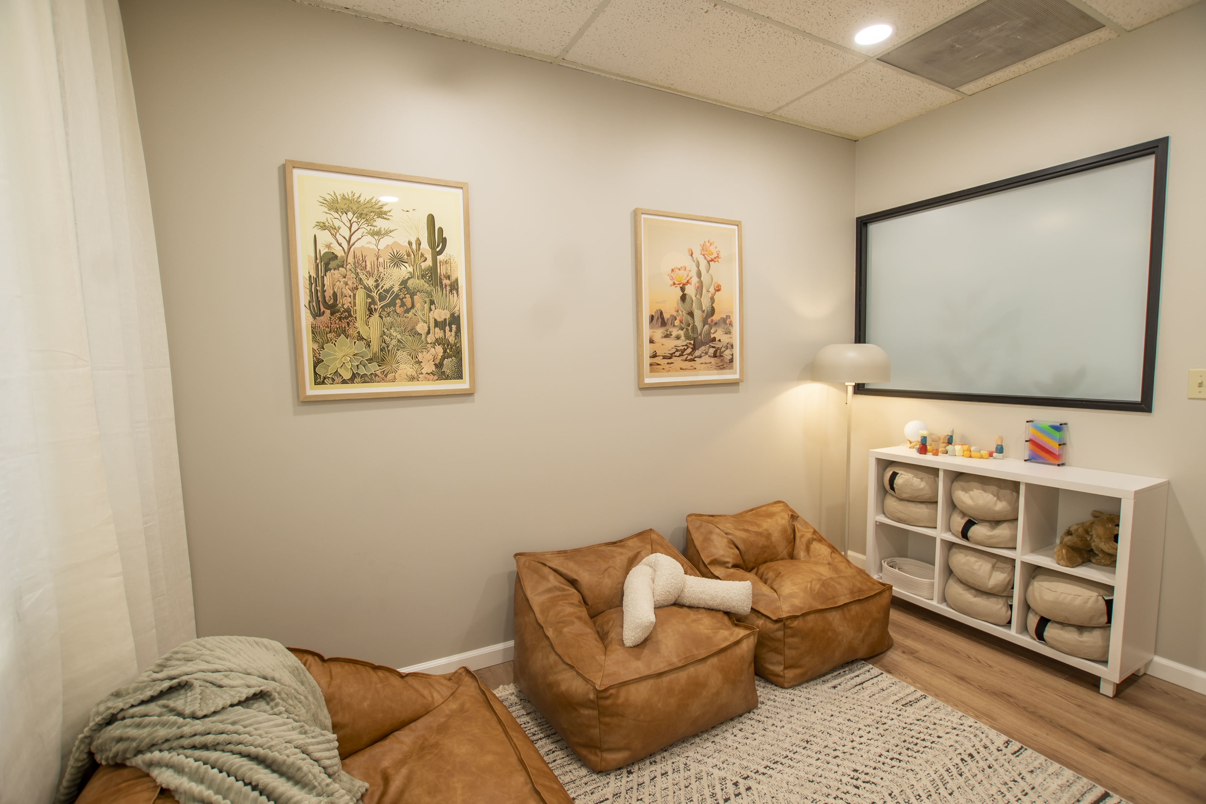 A therapy room with bean bag chairs, soft lighting, and decor.